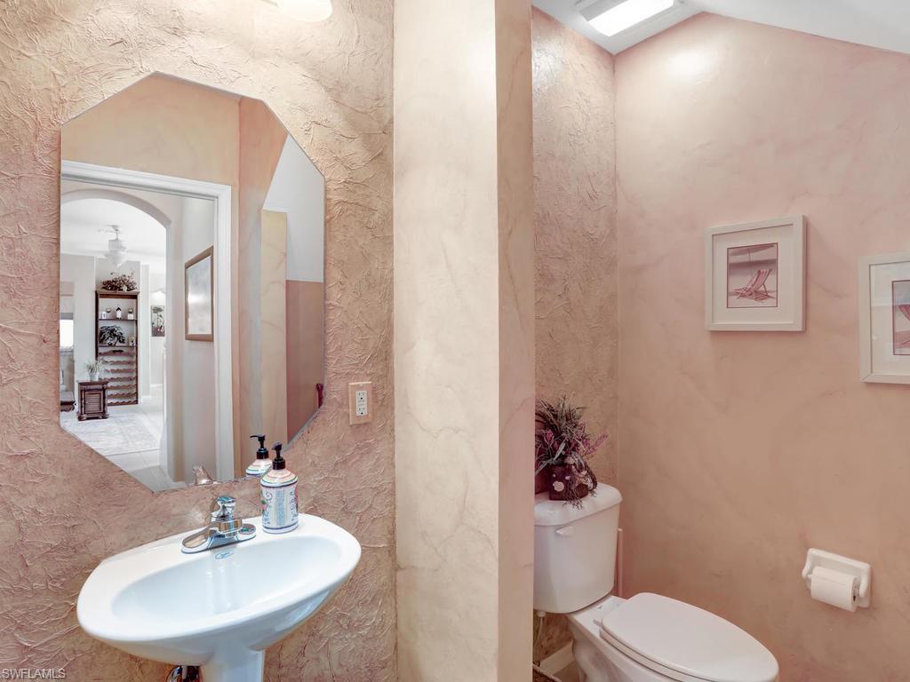 5786 Lago Villaggio Way Naples, FL 34104 - Photo 8 of 29 a bathroom with a toilet sink and mirror