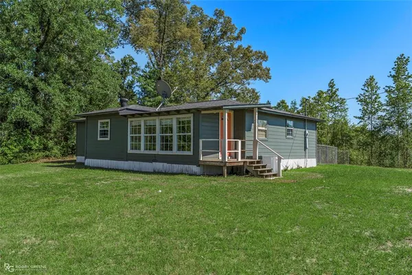 a view of a house with a yard and sitting area