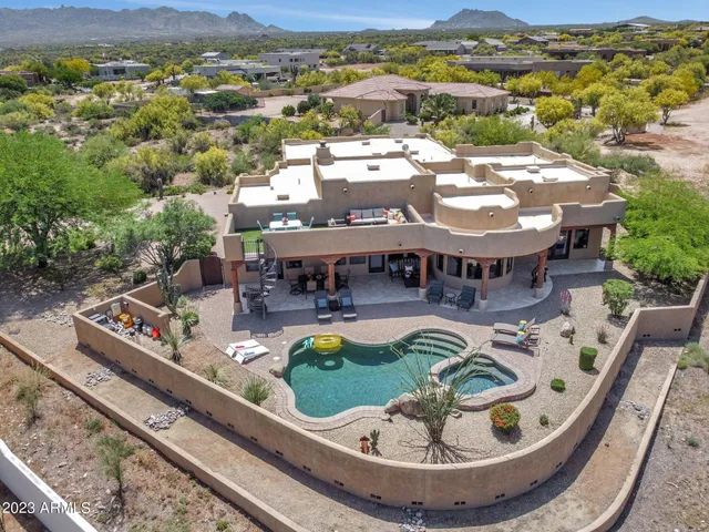 an aerial view of a house with swimming pool mountain view in back