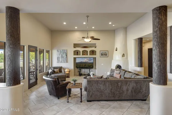 a living room with fireplace furniture and a large window
