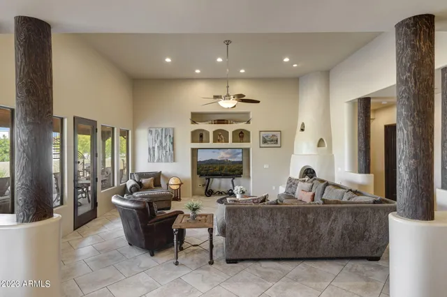 a living room with fireplace furniture and a large window