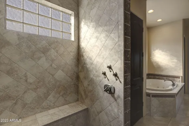 a bathroom with double vanity sinks a vanity a lamp and a bathtub