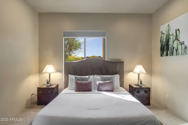 a bedroom with a bed and a painting on the wall