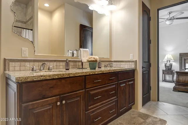 a bathroom with a granite countertop bathtub shower and toilet
