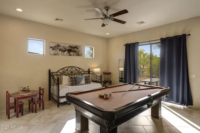 a living room with furniture pool table and a flat screen tv