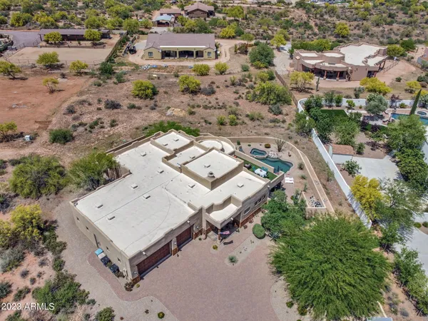 an aerial view of a house with a yard and a large tree