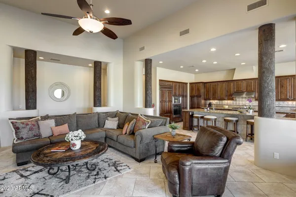 a living room with furniture kitchen view and a large window