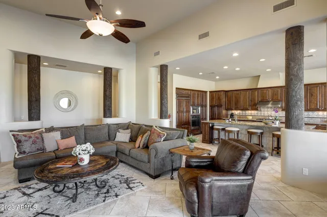 a living room with furniture kitchen view and a large window