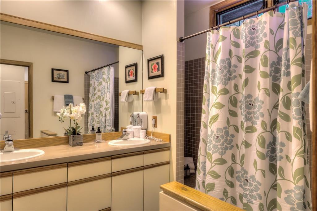 2017 Soda Ridge Road, Unit 1943 Keystone, CO 80435 - Photo 14 of 21 a bathroom with a granite countertop sink a mirror and a shower