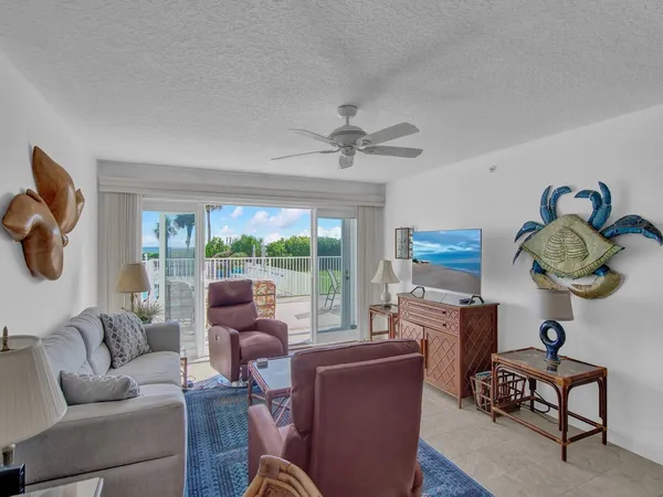 a living room with furniture a fireplace and a floor to ceiling window