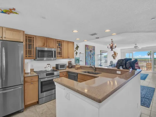 a kitchen with stainless steel appliances granite countertop a sink a stove and a refrigerator