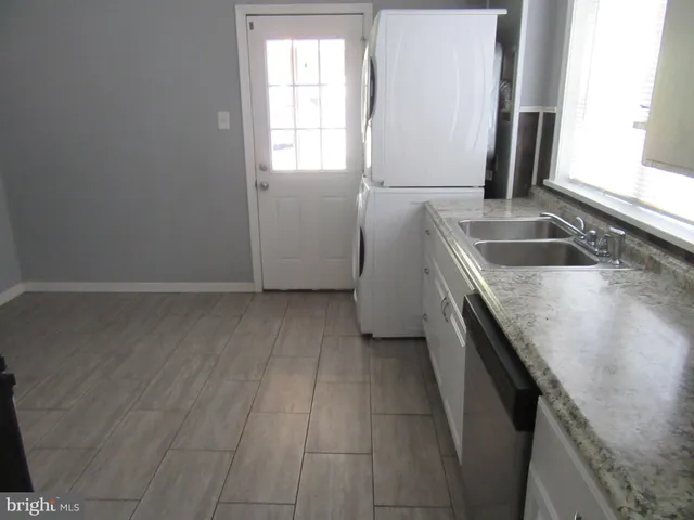 a kitchen with a sink a microwave a window and a refrigerator