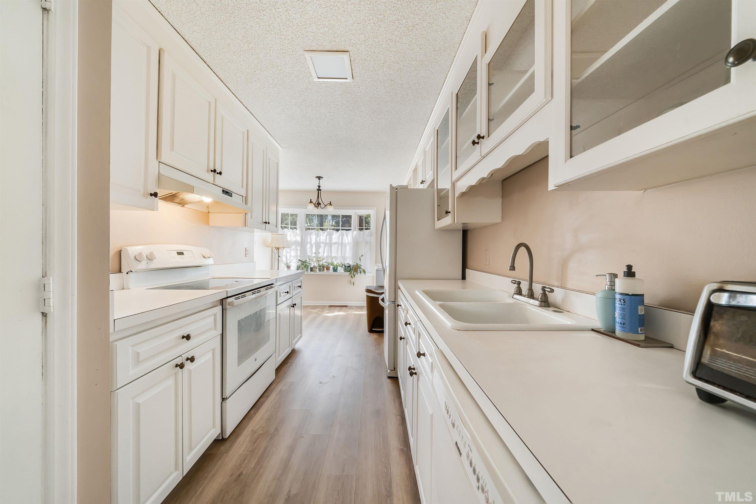 2890 Wycliff Road Raleigh, NC 27607 - Photo 8 of 16 a kitchen with sink a stove and cabinets