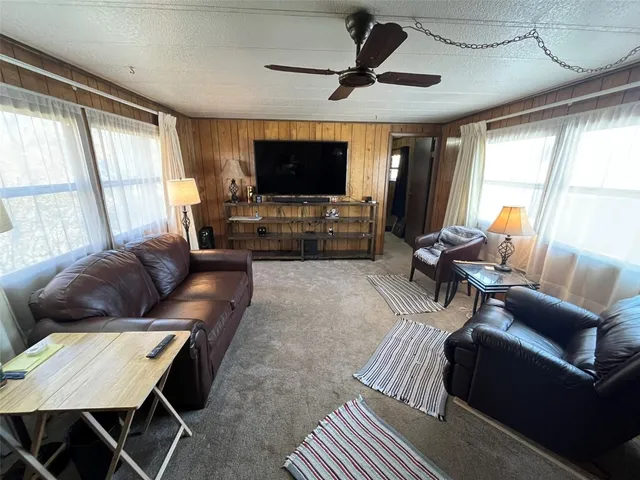 a living room with furniture a flat screen tv and a large window