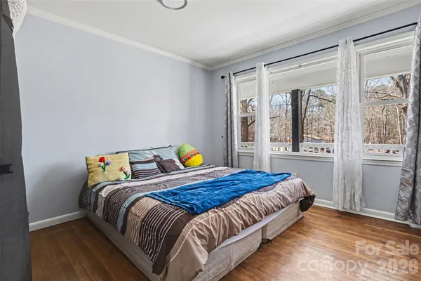 a bedroom with a bed and wooden floor