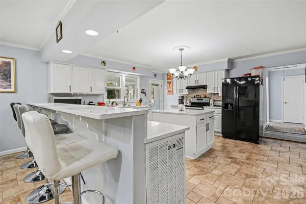 a kitchen with stainless steel appliances kitchen island granite countertop a refrigerator and a stove top oven