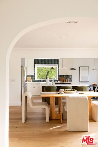 a kitchen with stainless steel appliances a stove a sink and white cabinets