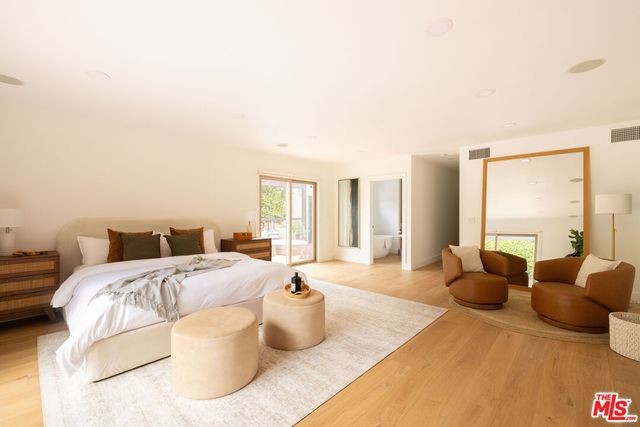 a large bedroom with a bed and large windows