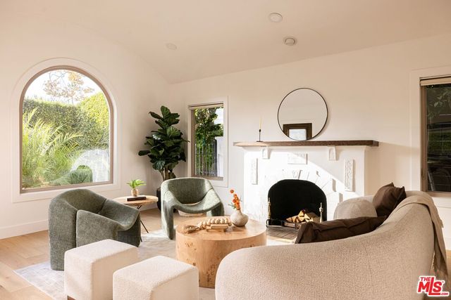 a living room with furniture a fireplace and potted plants
