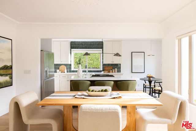 a kitchen with kitchen island a stove a table and chairs