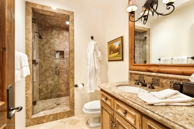a bathroom with a granite countertop sink toilet and shower