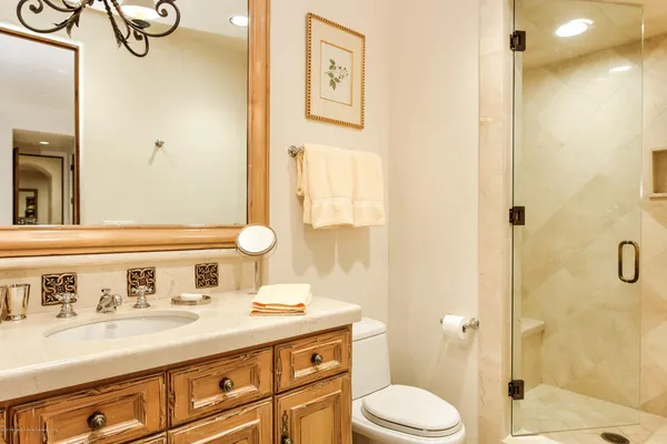 a bathroom with a granite countertop sink toilet and shower