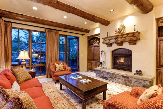 a living room with furniture a fireplace and a large window