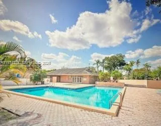 a view of a big house with a big yard and large trees