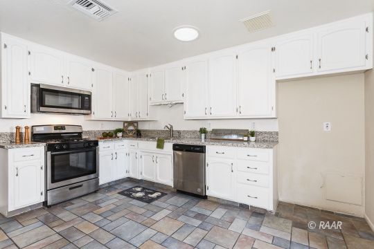 640 Sydnor Avenue Ridgecrest, CA 93555 - Photo 10 of 28 a kitchen with granite countertop white cabinets and stainless steel appliances