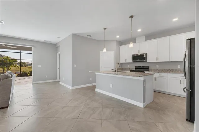 a view of a kitchen with a refrigerator a microwave and a sink