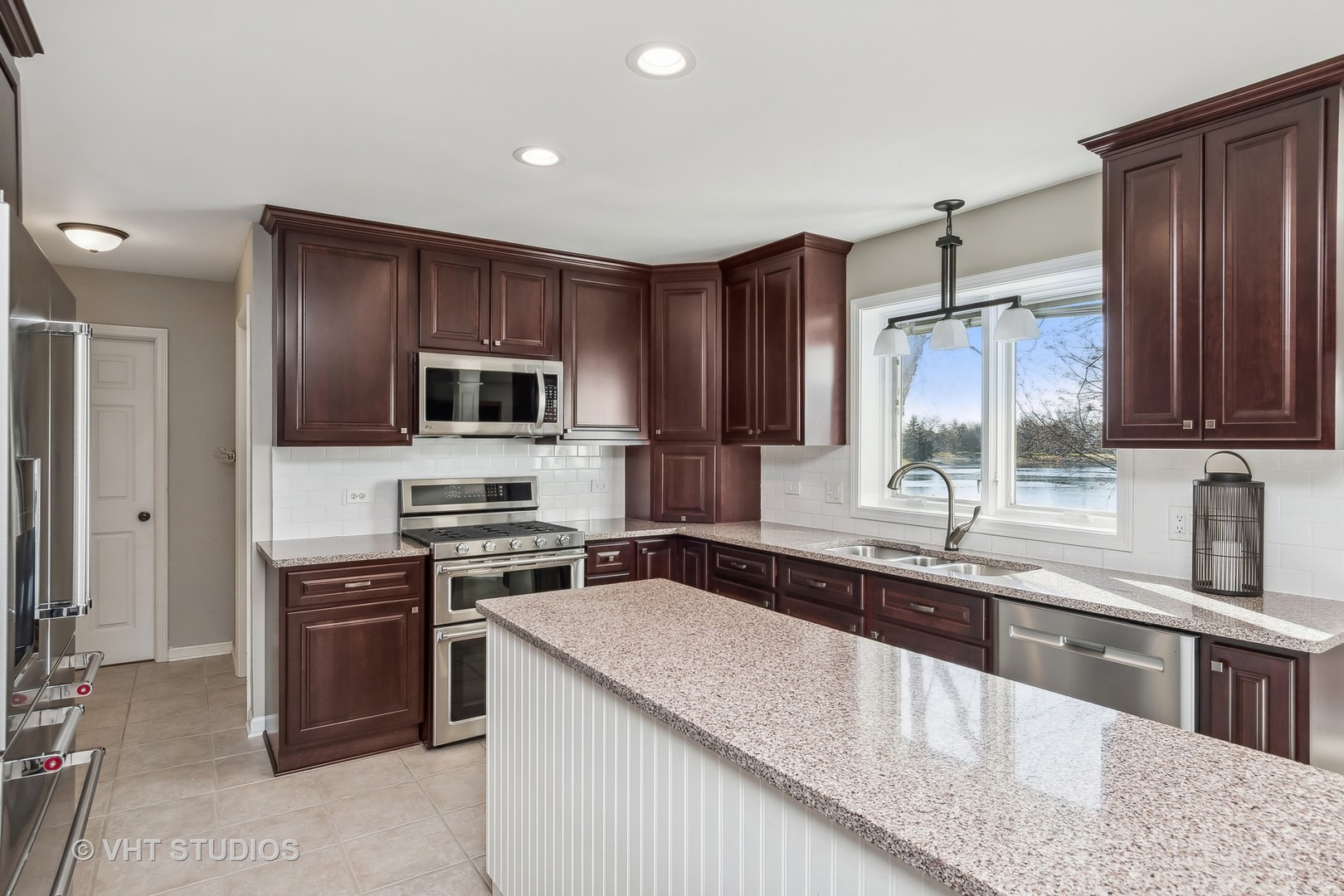 13344 Round Barn Road Plainfield, IL 60585 - Photo 3 of 24 a kitchen with stainless steel appliances granite countertop a sink stove microwave and refrigerator