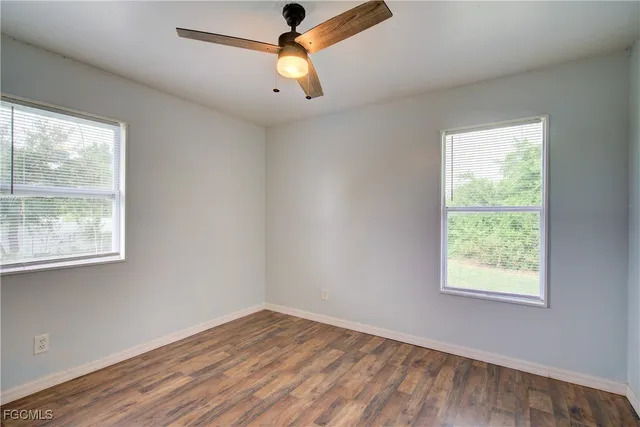 an empty room with a window and wooden floor