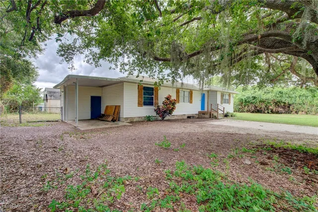 a view of a house with backyard and a tree