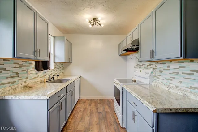 a kitchen with a sink stove and cabinets