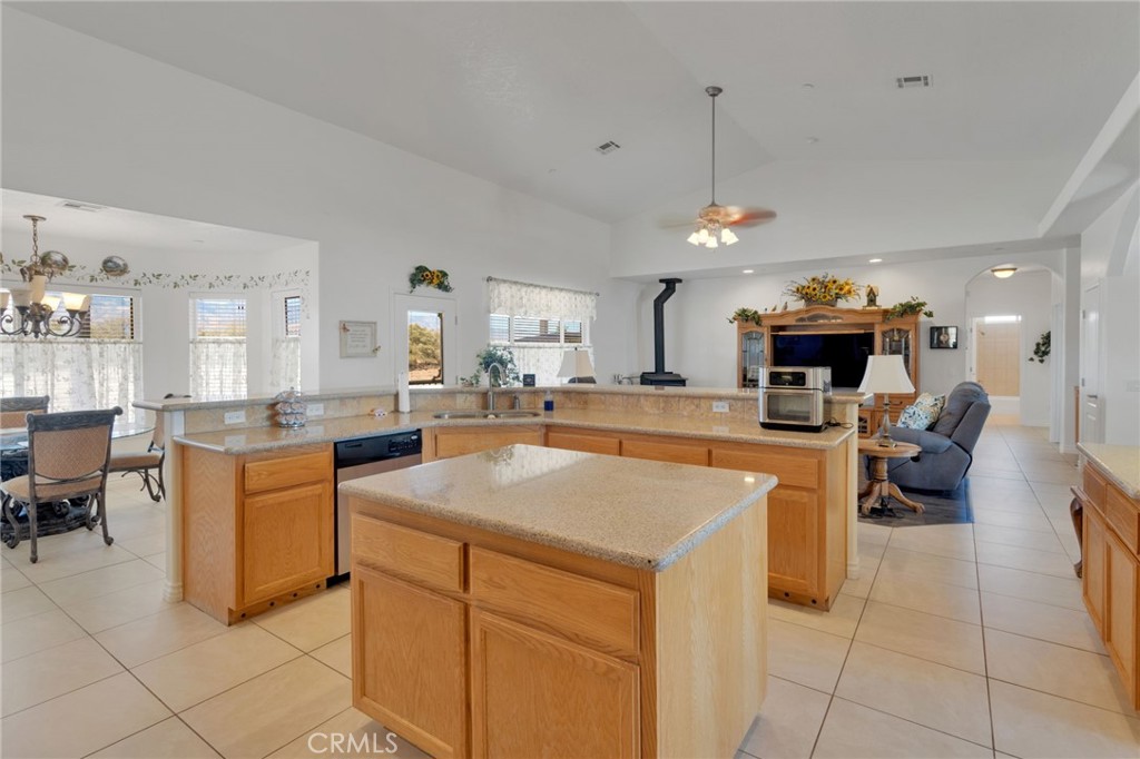 8482 Tumbleweed Road Phelan, CA 92371 - Photo 13 of 61 a kitchen with stainless steel appliances kitchen island granite countertop a sink dishwasher and white cabinets with wooden floor