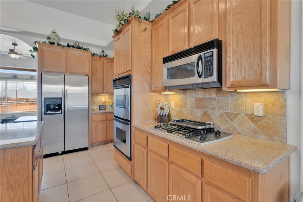 8482 Tumbleweed Road Phelan, CA 92371 - Photo 19 of 61 a kitchen with stainless steel appliances granite countertop a stove a refrigerator and a microwave