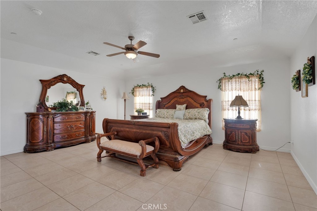 8482 Tumbleweed Road Phelan, CA 92371 - Photo 21 of 61 a bedroom with a bed and a chandelier