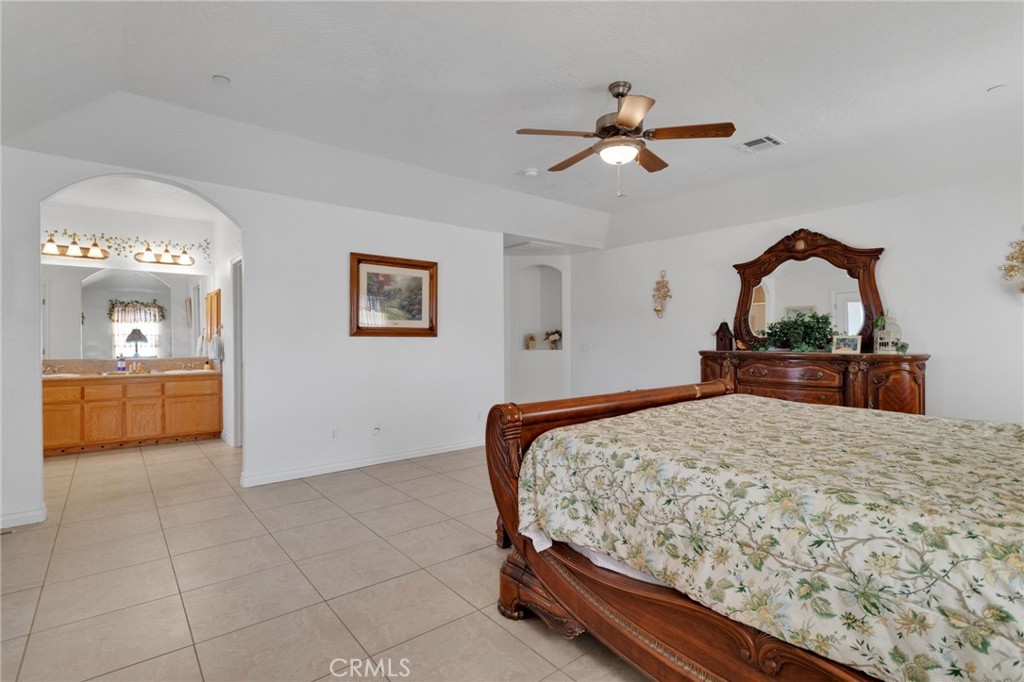 8482 Tumbleweed Road Phelan, CA 92371 - Photo 22 of 61 a bedroom with a bed and a chandelier