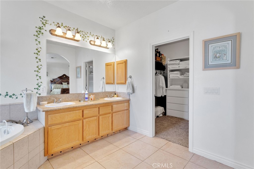 8482 Tumbleweed Road Phelan, CA 92371 - Photo 25 of 61 a spacious bathroom with a double vanity sink a mirror and a bathtub