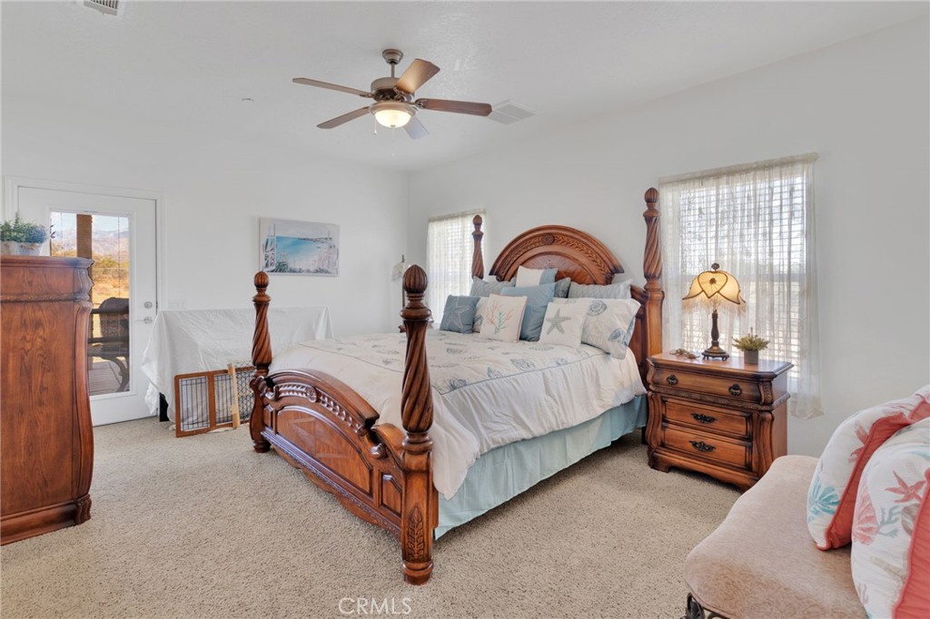 8482 Tumbleweed Road Phelan, CA 92371 - Photo 33 of 61 a spacious bedroom with a bed and a chandelier