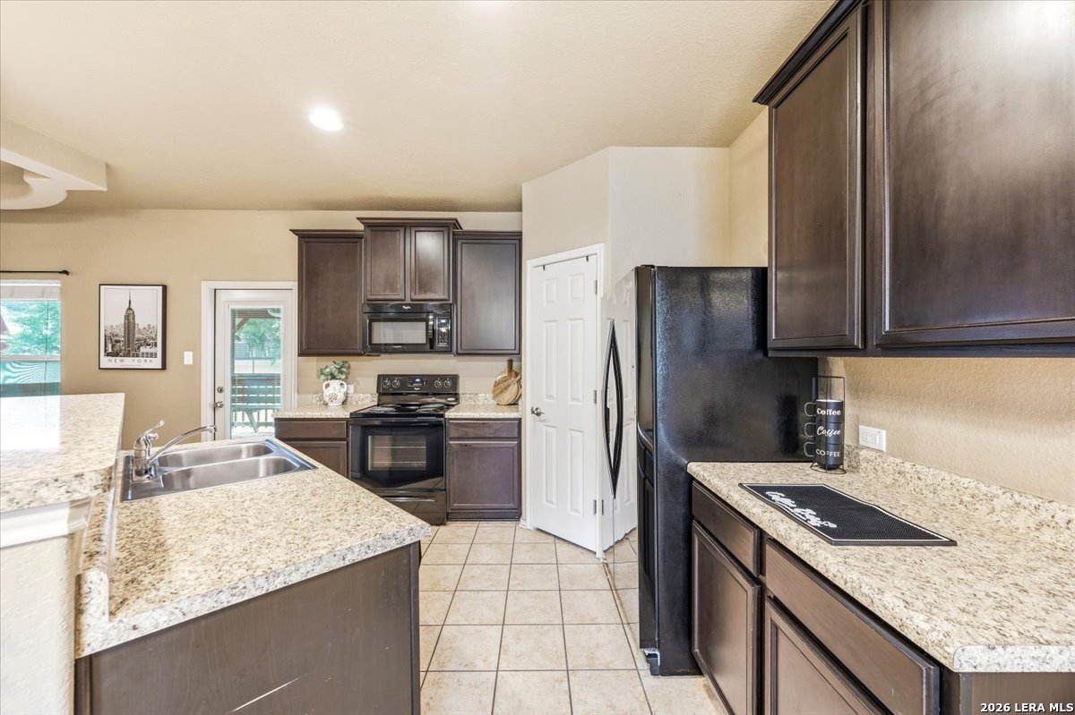 3831 Bacall Way Converse, TX 78109 - Photo 10 of 33 a kitchen with granite countertop stainless steel appliances and wooden cabinets