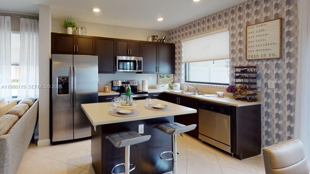 a kitchen with stainless steel appliances granite countertop a sink refrigerator and cabinets