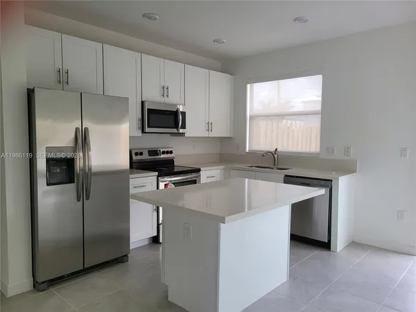 a kitchen with stainless steel appliances a refrigerator sink and microwave