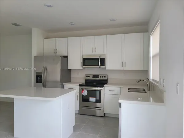 a kitchen with stainless steel appliances white cabinets and a sink