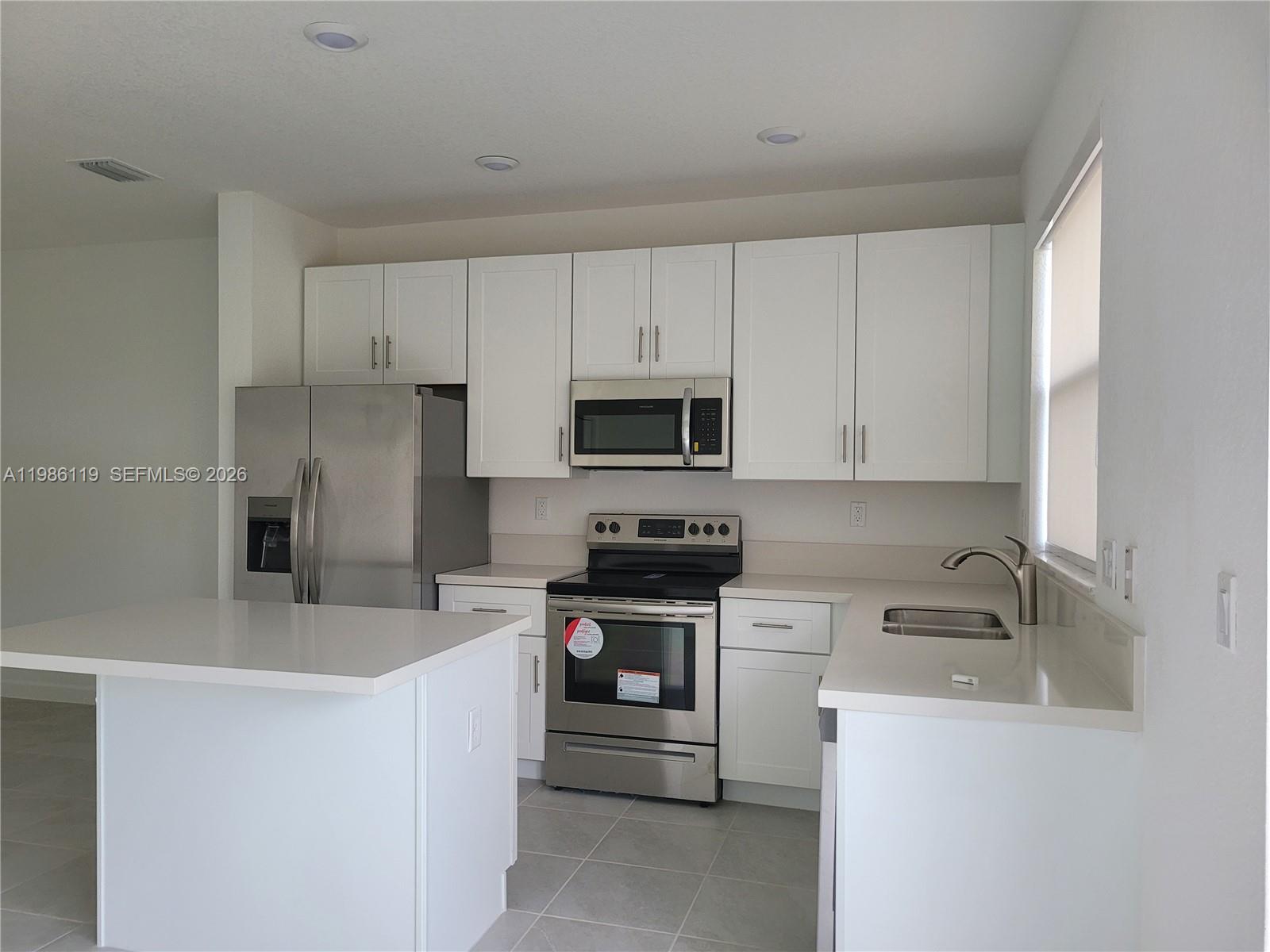 28667 Southwest 132nd Court Homestead, FL 33033 - Photo 16 of 20 a kitchen with stainless steel appliances white cabinets and a sink
