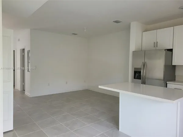 a view of a kitchen with a sink dishwasher and a refrigerator