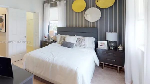 a bedroom with a bed and painting on the wall