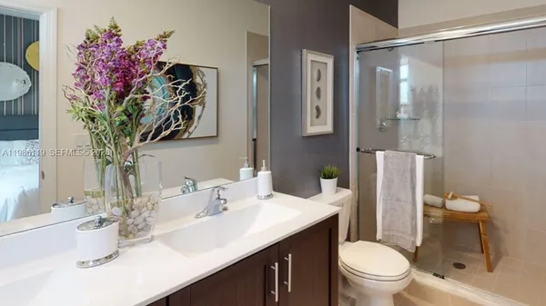 a bathroom with a sink vanity mirror and toilet