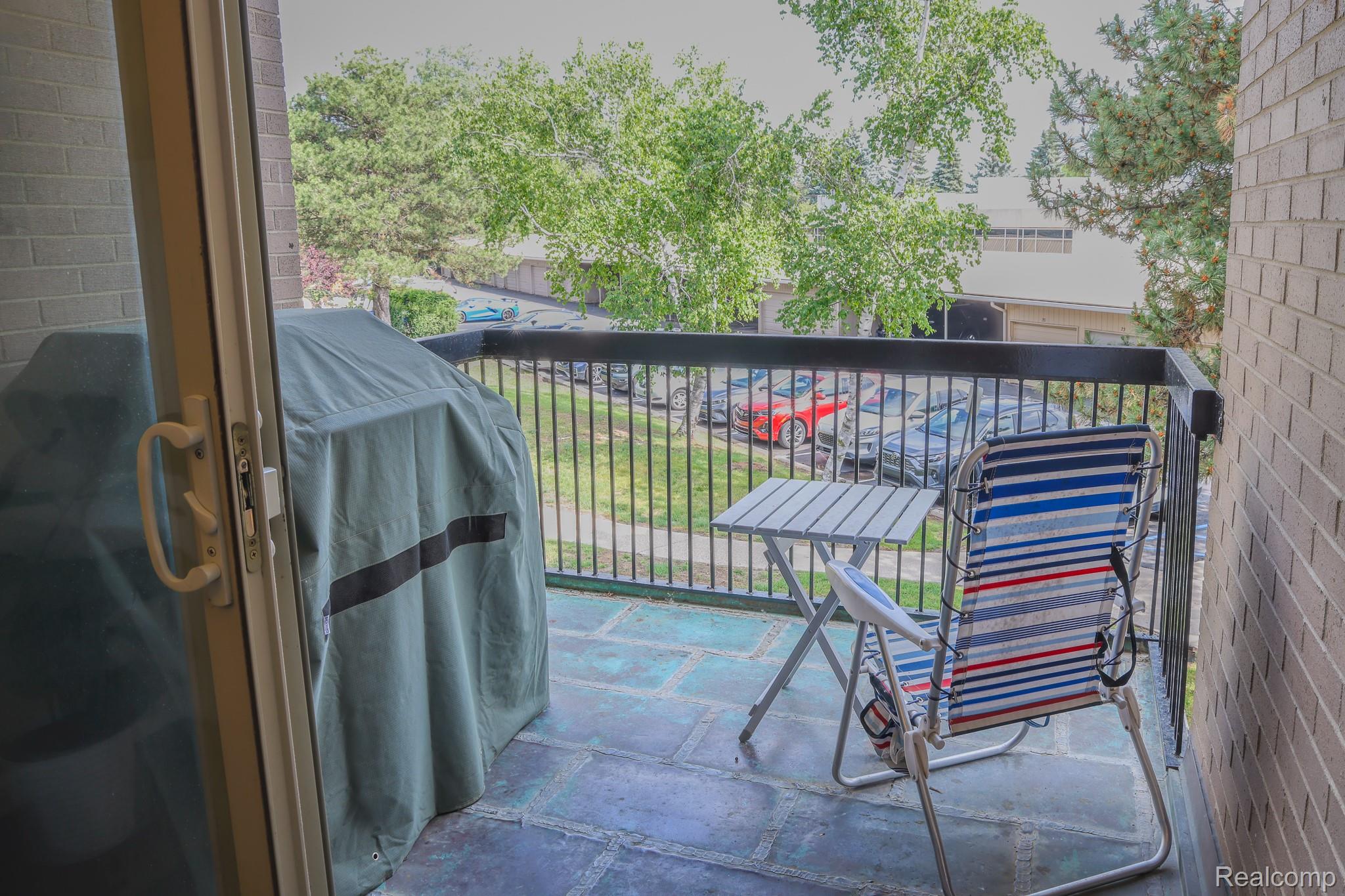 1989 Klingensmith Road, Unit 46 Bloomfield Hills, MI 48302 - Photo 13 of 41 Private balcony featuring stone tile flooring and a black metal railing