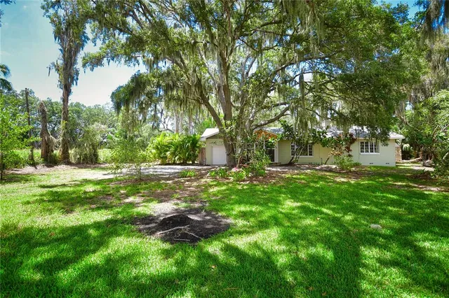 a view of a house with yard and sitting area